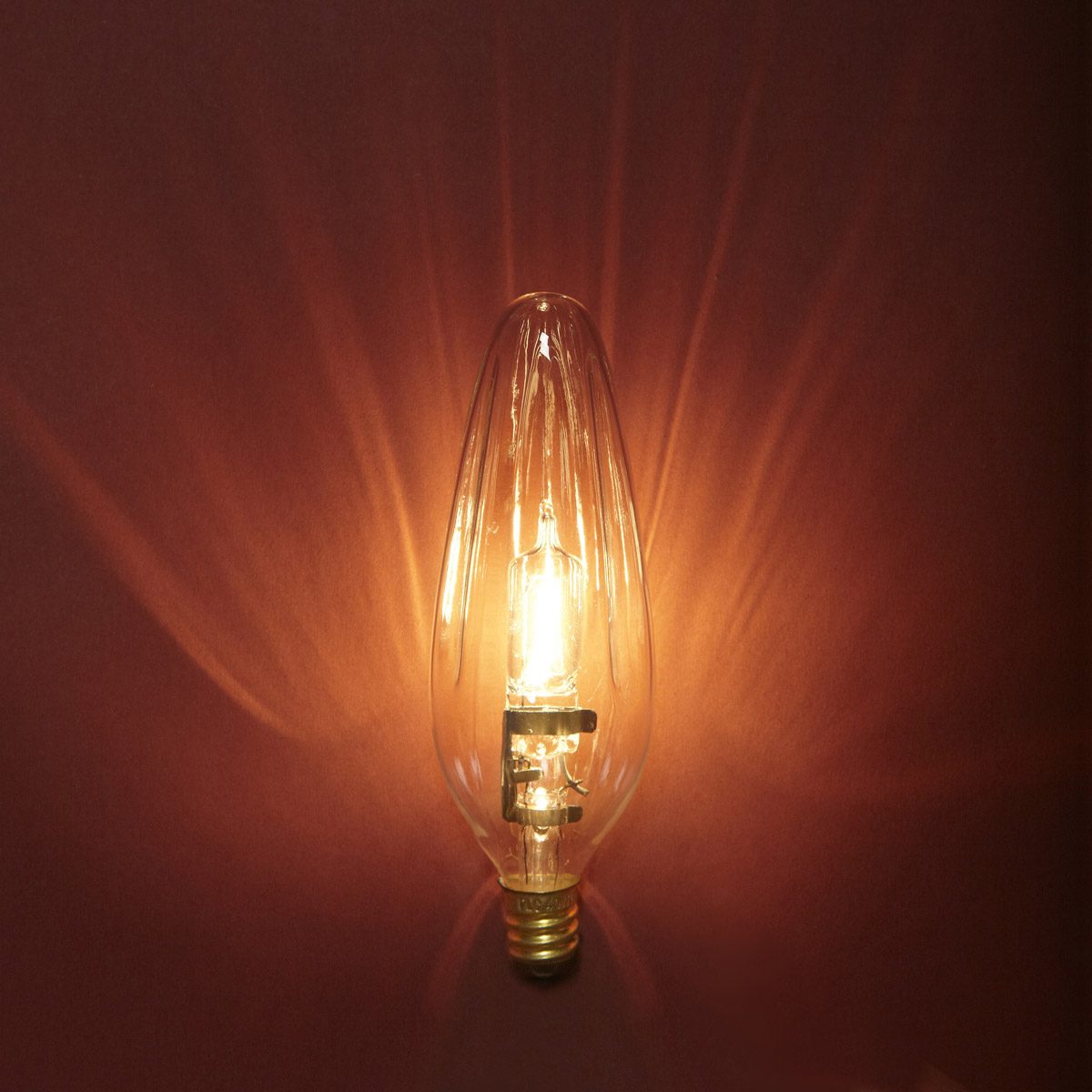 A vintage light bulb glows warmly, illuminating a wall with soft rays, creating a cozy, inviting atmosphere in the surrounding space.