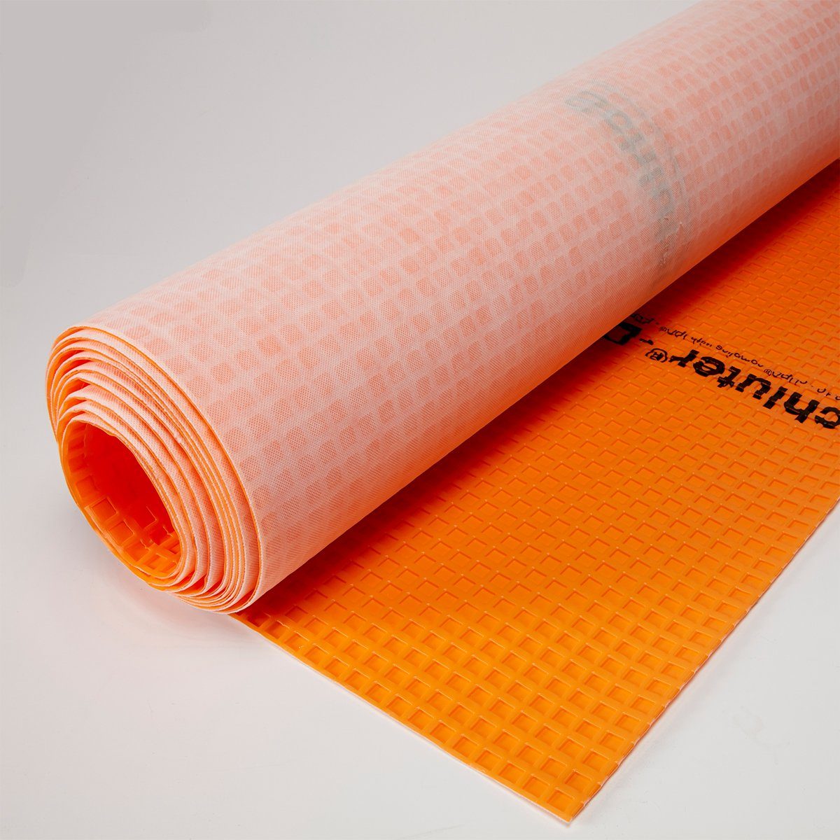 A rolled, textured orange mat is partially unrolled, showcasing its grid pattern, suggesting use for exercise or yoga on a flat surface.