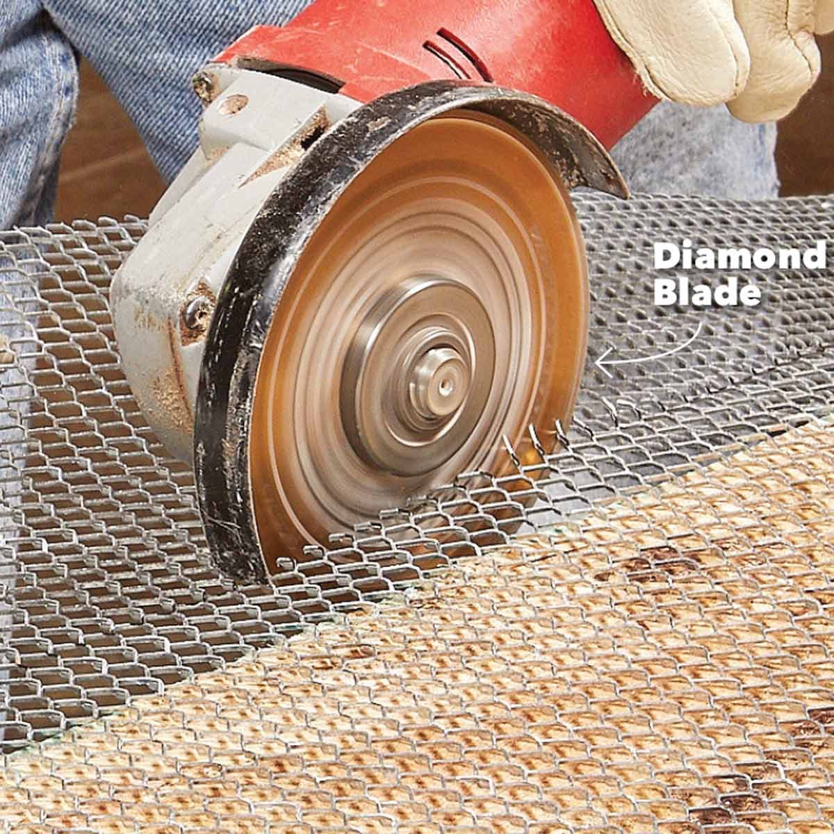 A power tool with a spinning diamond blade cuts through wire mesh on a work surface, while a gloved hand guides it.