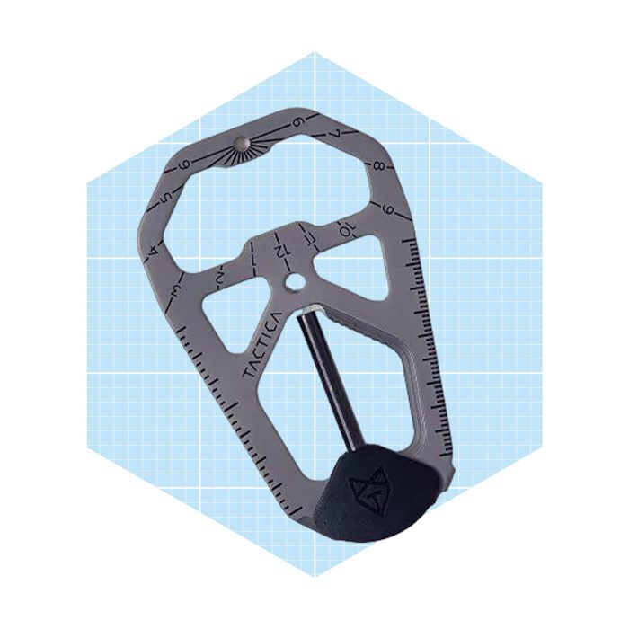 A metallic multi-tool displays various measurement markings. It's set against a light blue grid background, suggesting utility and precision in outdoor or tactical settings.