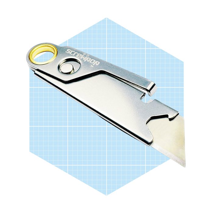A silver utility knife rests on a light blue grid background, showcasing its pointed blade and a circular hole for attachment.