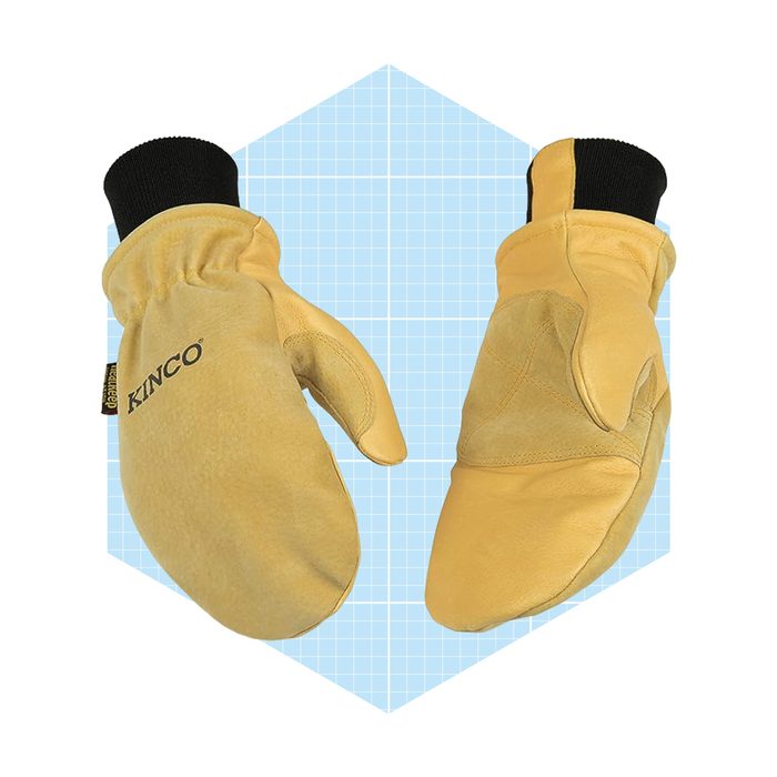 Mittens with a soft leather exterior rest on a light blue geometric background, showcasing their design for warmth and protection during cold weather activities.