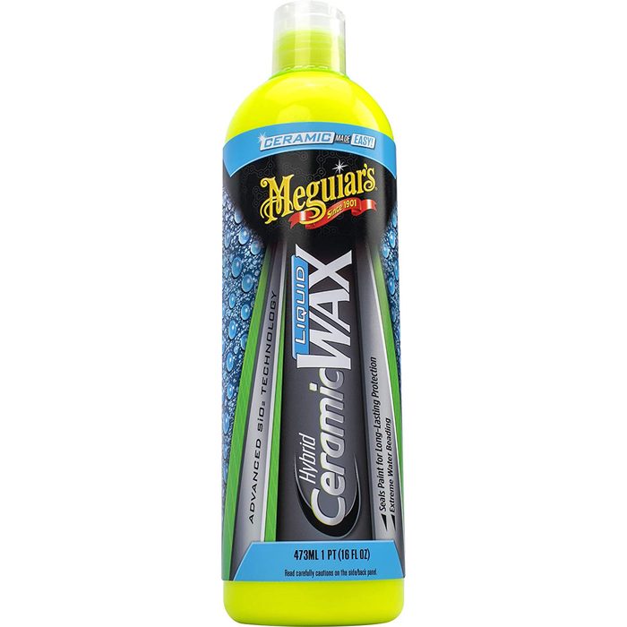 A bottle of Meguiar's Hybrid Ceramic Wax stands upright, with a bright yellow cap, featuring blue and black labels displaying product information and usage instructions.