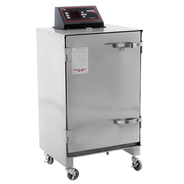 A stainless steel smoker cabinet stands on wheels, featuring a digital control panel on top and a securely closed front door, used for cooking food.