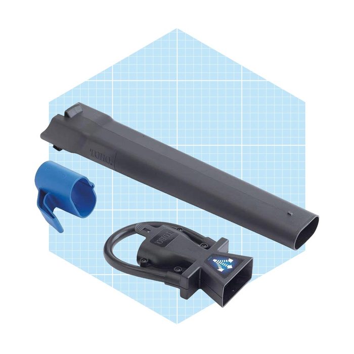 A black tool attachment set rests on a light blue grid background, including a long tube, a connector, and a blue plastic cap for protection.