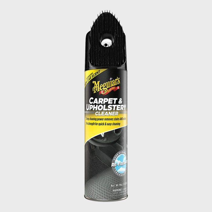 A spray can of carpet and upholstery cleaner removes stains, surrounded by a clean backdrop, emphasizing its use for quick and easy cleaning in vehicles.