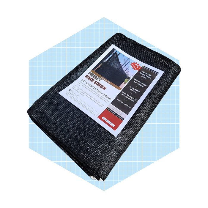 A folded black privacy fence screen lies on a light blue grid background, featuring a label with product details and images related to its use.