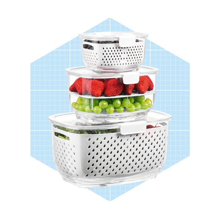 Three stacked storage containers hold fresh fruits: strawberries and green grapes, set against a light blue grid background.