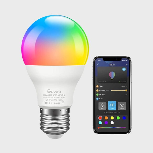 A colorful smart light bulb emits vibrant hues while a smartphone displays control options, set against a neutral gray background.
