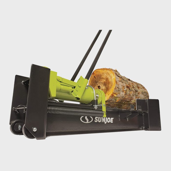 A log grapple attached to machinery is lifting a tree log, showcasing its mechanical design and functionality in a forestry or landscaping context.