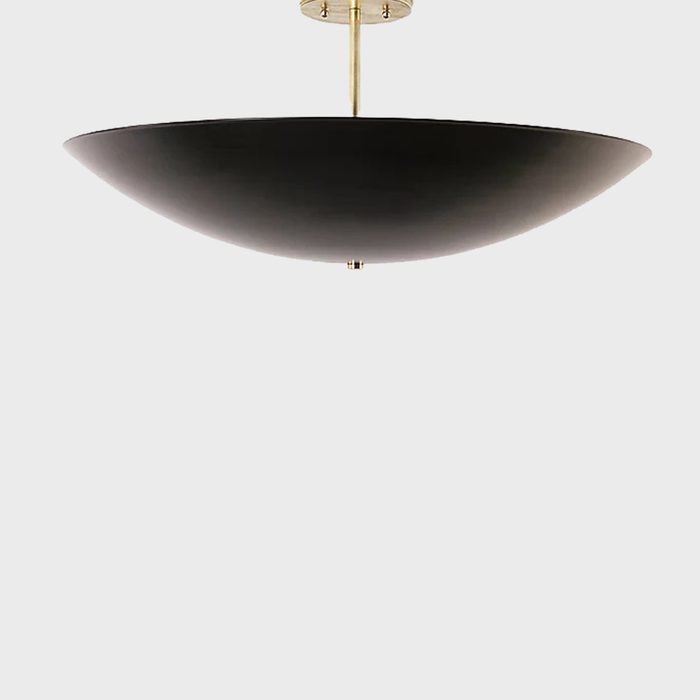 A black ceiling light hangs from a gold fixture, creating a modern accent in a minimal, neutral space.