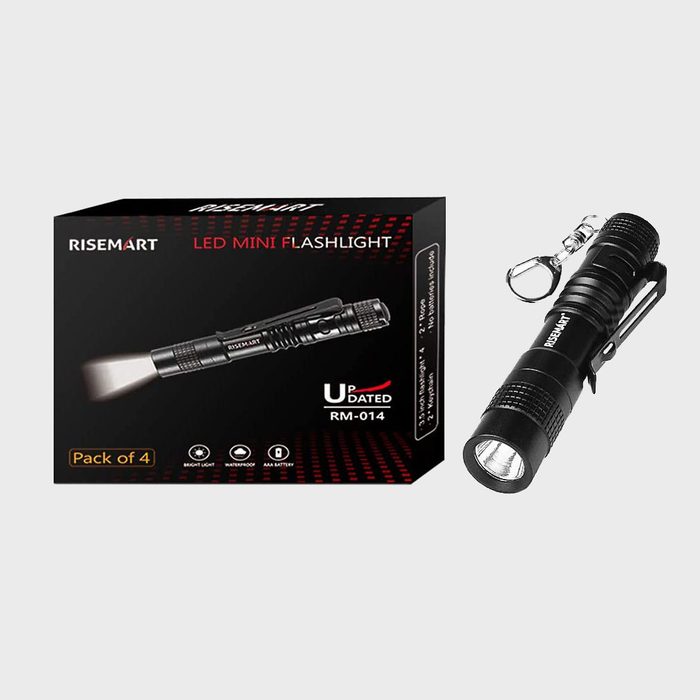 A black LED mini flashlight, positioned next to its packaging, is designed for portable use, featuring a clip and keychain hole for convenience.