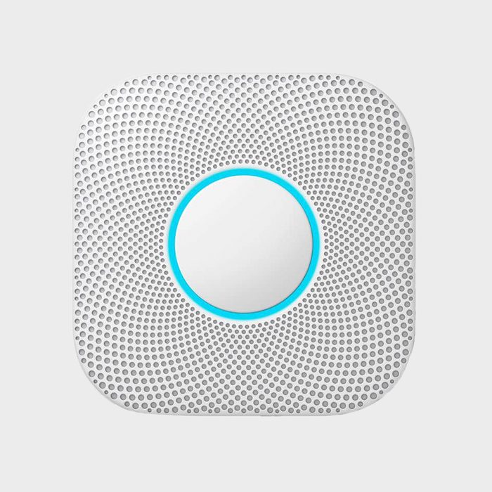 A circular device with a central mirror, surrounded by a textured white surface, displays a blue outline, suggesting it's a modern smart home product.
