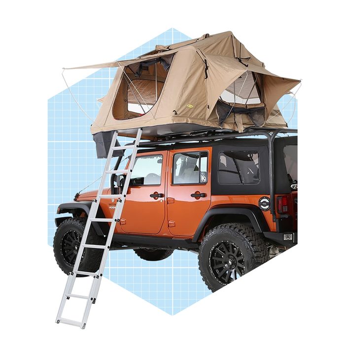 A rooftop tent is secured atop an orange SUV, with a ladder leading to it, set against a light blue grid background.