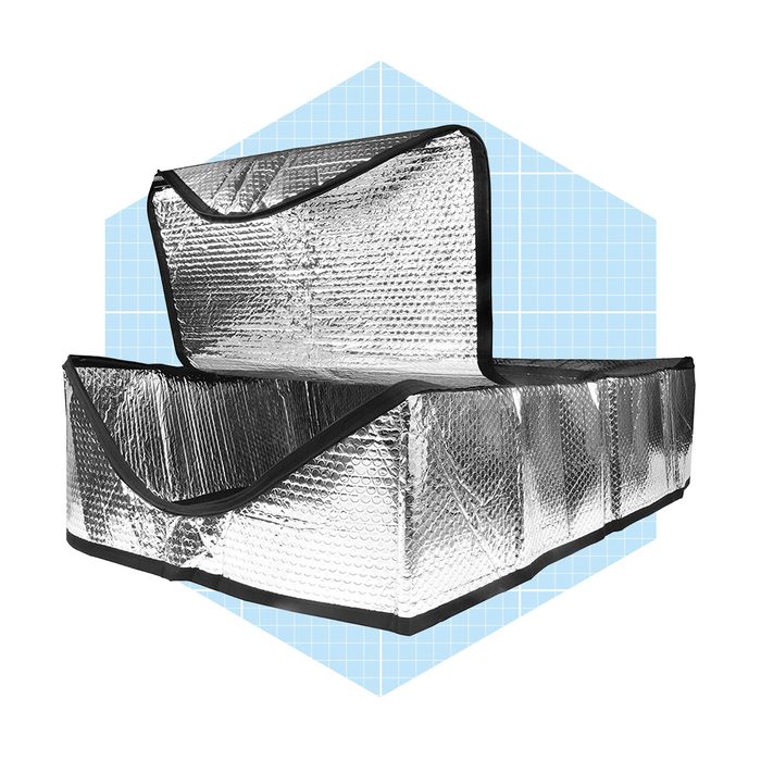 A reflective silver container stands open, showcasing its spacious interior, set against a light blue geometric background.