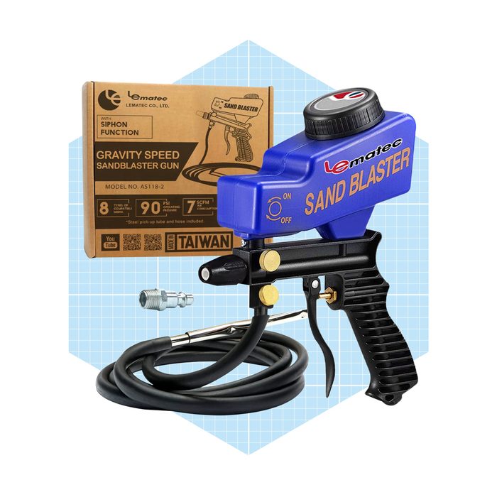 A blue sandblaster gun is positioned beside its packaging, featuring specifications and a connector, set against a light grid background.