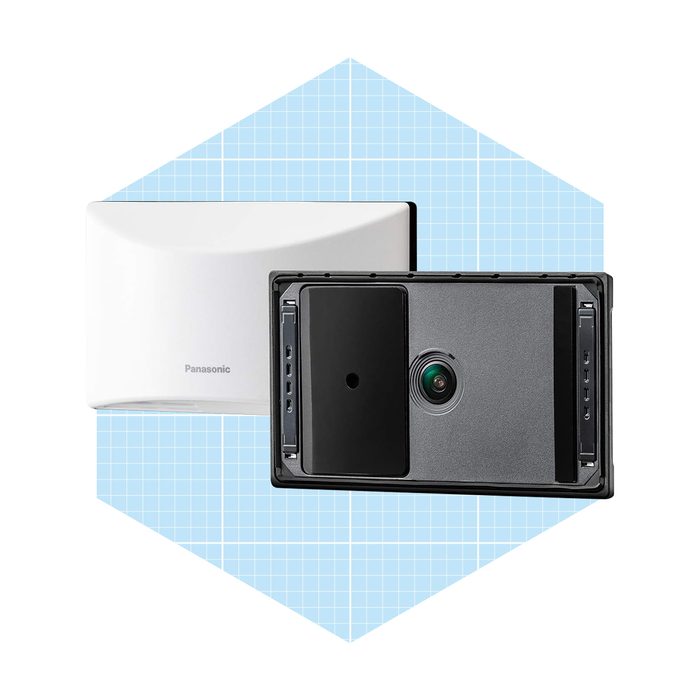 A dual-component device is resting against a blue grid background. The front part features a camera lens, while the back is a smooth, white casing.