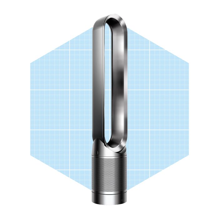 A sleek, metallic fan stands upright, circulating air, set against a light blue grid background. Its design is modern and minimalistic.