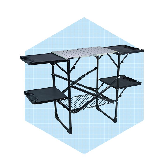 A folding shelf unit stands upright, featuring multiple black shelves and a central metal tabletop, set against a light blue grid background.