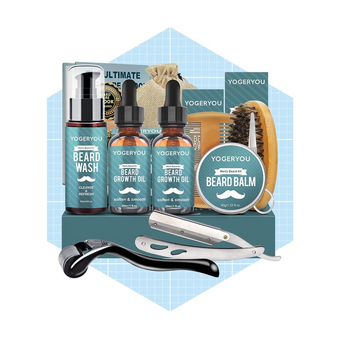 A men's beard care kit contains beard wash, growth oil, balm, a brush, a comb, and a razor, arranged on a blue background.