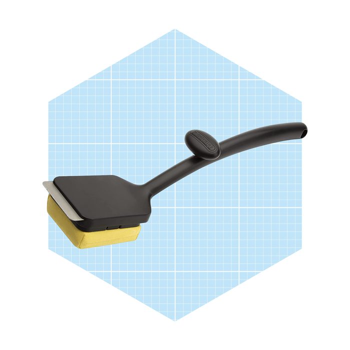 A cleaning tool with a flat, rectangular head and a soft yellow sponge is positioned against a light blue grid background.