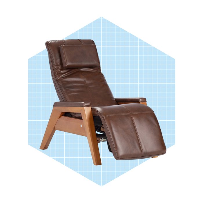 A reclining chair is positioned at an angle, featuring brown leather upholstery and wooden legs, set against a light blue grid-patterned background.