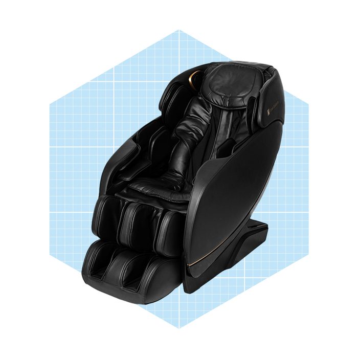 A black massage chair reclines, designed for relaxation. Set against a light blue grid background, it appears modern and inviting for therapeutic use.