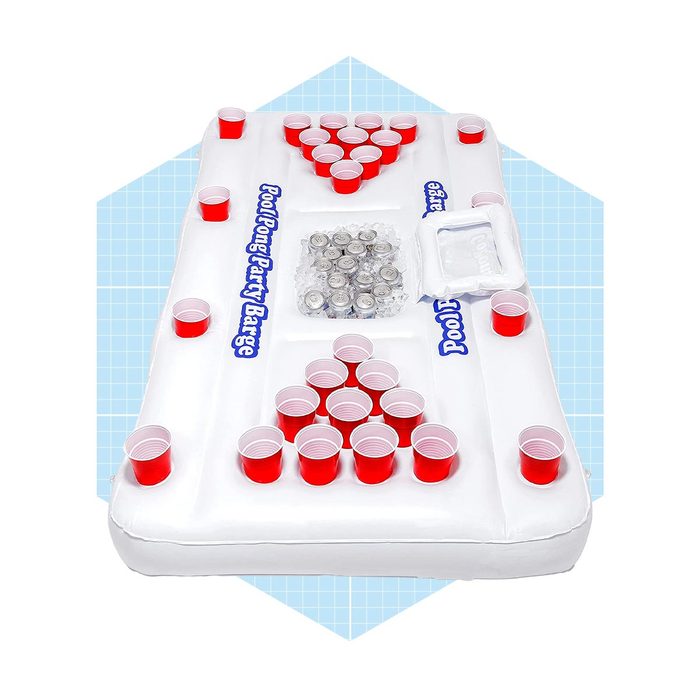An inflatable pool bar features numerous red cups arranged in triangle formations and a cooler for drinks, designed for social gatherings near water.