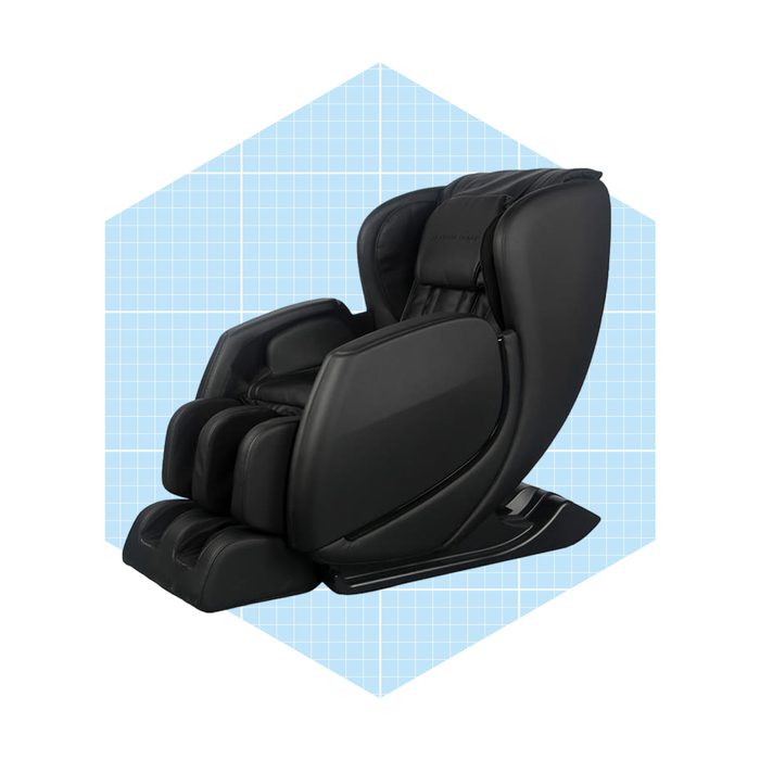 A black massage chair reclines, featuring plush cushioning and a sleek design, set against a light blue grid background.