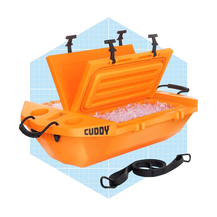 An orange cooler with a raised lid contains ice, featuring side handles and a shoulder strap, set against a light blue grid background.