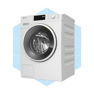 A white washing machine spins clothes inside a transparent door, featuring a digital control panel, against a light blue geometric background.
