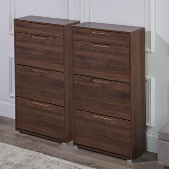 Two wooden dressers with six drawers each stand side by side against a wall, set on a wooden floor, with a plush rug nearby.