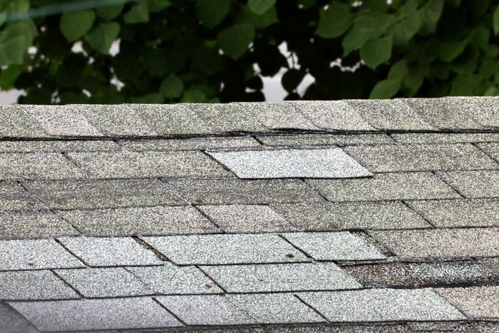 Damaged roof With replacement shingles